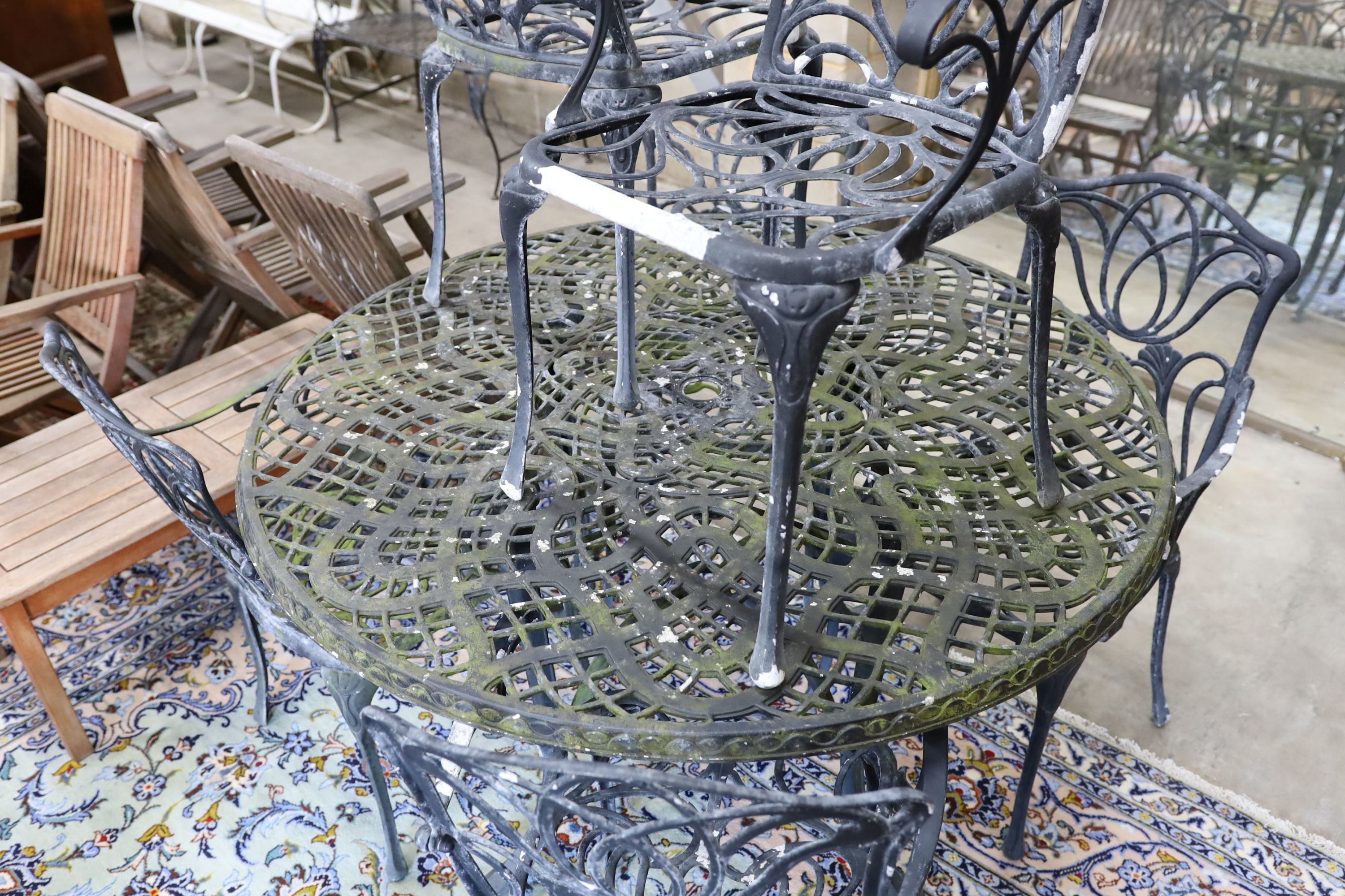 A painted aluminium circular garden table, diameter 124cm, height 73cm and six aluminium garden elbow chairs